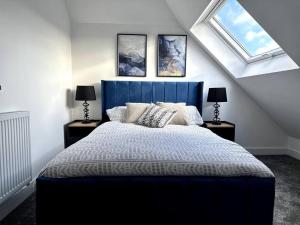 Brand new modern Cheltenham home的一间卧室设有蓝色的床和2个窗户。