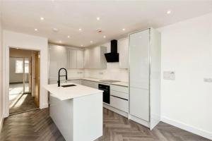 Brand new modern Cheltenham home的白色的厨房配有白色橱柜和水槽
