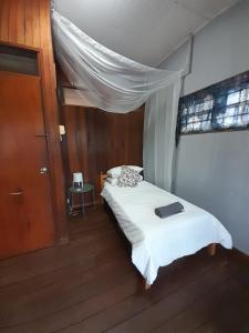 吉隆坡Preece's B & B的一间小卧室,配有一张带白色毯子的床