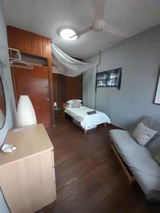 吉隆坡Preece's B & B的一间卧室配有两张床、一张桌子和一张沙发