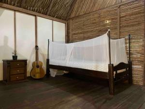 帕洛米诺Casa Moringa的卧室配有一张床和一把吉他