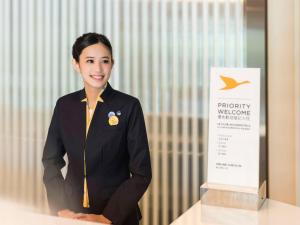 大园区台北诺富特华航桃园机场饭店的身着制服的女手站在标志旁边