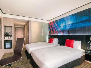 大园区台北诺富特华航桃园机场饭店的酒店客房配有一张带红色枕头的大床