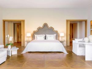 科梅诺Corfu Imperial, Grecotel Beach Luxe Resort的卧室配有白色大床和白色家具