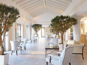卢特拉基利尼斯Grecotel La Riviera & Aqua Park的大堂设有桌椅和树木