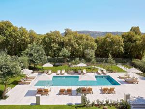 阿德里安诺斯坎波斯Villa Oliva的毗邻度假酒店的带椅子和遮阳伞的游泳池