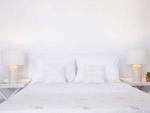 锡西格雷科泰尔梅利皇宫酒店的配有白色枕头和两盏灯的白色床