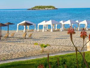 锡西格雷科泰尔梅利皇宫酒店的海滩上的一把遮阳伞和椅子