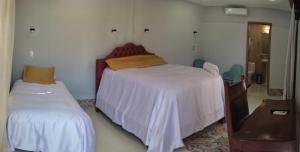 里瓦斯HOSTAL RIVAS INNS的一间卧室配有两张床、一个梳妆台和镜子