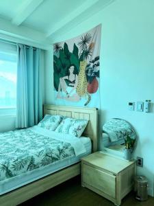 济州市Aewol Gwangryeong House的卧室配有一张床,墙上挂有绘画作品