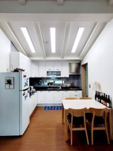 济州市Aewol Gwangryeong House的厨房配有桌子和白色冰箱。