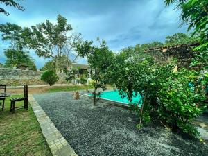 达瓦拉维Lily Resort Udawalawe的后院设有游泳池和树