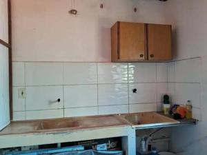 伊列乌斯Apartamento em Ilhéus的一个带水槽和木橱柜的厨房