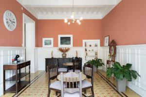 利马Casa Cáceres的一间拥有橙色墙壁和桌椅的用餐室
