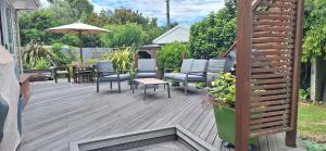 纳尔逊Reeves Retreat-Handy in Tasman的一个带桌椅和遮阳伞的甲板