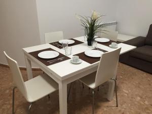 特鲁埃尔Apartamento Centro Historico Teruel的一张白色的桌子,上面有白色的椅子和盘子