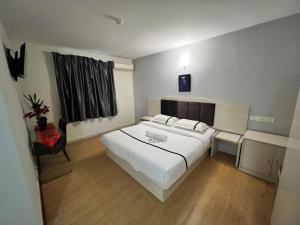 吉隆坡Seeds Hotel Cheras Maluri的卧室配有一张白色大床和一把椅子