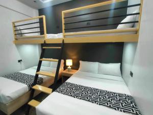 纳苏格布SANDS Hotel Nasugbu的小房间设有两张双层床和一张书桌