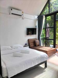 Ban Tha Phaep.p. hill & house的白色卧室配有一张大床和椅子