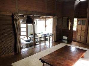 YumotoTabino Camping Base Akiu Tree House - Vacation STAY 23970v的客厅铺有木地板,配有桌子。