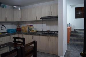 通苏帕Casa privada en Tonsupa con piscina的厨房配有木制橱柜、桌子和楼梯。