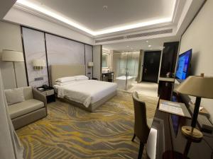 杭州杭州滨江开元名都大酒店的酒店客房配有床、沙发和电视。