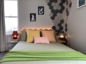 惠灵顿Central Nest- view & style的一间卧室配有一张带两盏灯的绿床。