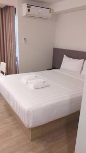 曼谷Prom Hotel的一张白色的床,上面有两条毛巾