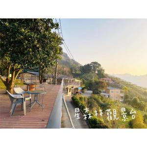 Dongshi星森林包棟住宿-台中東勢-山區景觀的木制甲板上配有桌椅