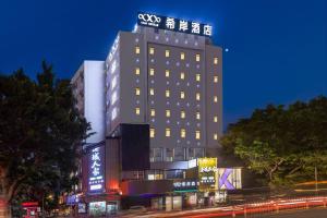 广州希岸酒店(广州江南西地铁站广百新一城店)的一座建筑物,上面有夜间标志