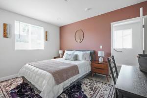 洛杉矶Good Shepard Homestay的卧室配有床、桌子和窗户。