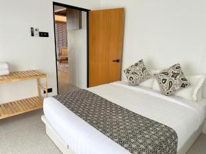 亚娄Arau House的卧室配有带枕头的白色床