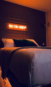 拉特里尼泰150 de Grey Studio pour 2 avec SPA, Vue sur mer的卧室内的一张床铺,墙上有标志