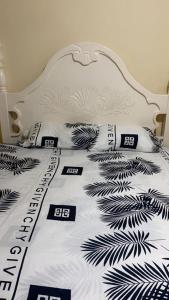 PINEVALLEY APT.SUITE 3A的白色的床,配有黑色和白色的床单和枕头
