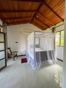 坦加拉Dinuri villa的一间卧室配有一张带蚊帐的床