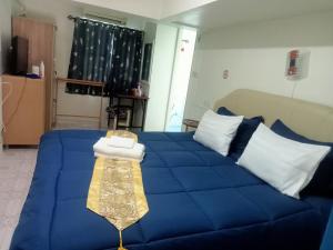 班佩幸福家园旅馆的一张带白色枕头和毯子的蓝色床