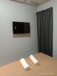 关丹D LAYARAN KUANTAN LPT Exit 833的一间卧室配有电视和两张桌子上的枕头