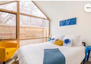 彼得伯勒Tiny House Haven的一间卧室配有一张大床和一张黄色椅子