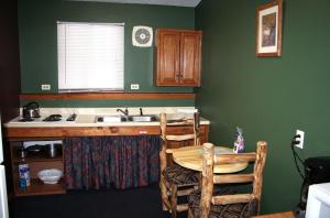 埃斯蒂斯帕克Timber Creek Chalets- 4 chalet的厨房设有绿色的墙壁、水槽和桌子