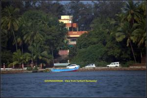 BhogweGovindaashram-Tarkarli的两辆汽车和一艘蓝色的船在水体上