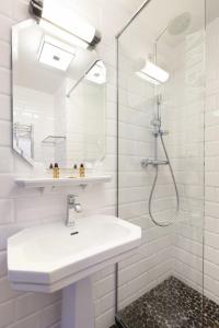 圣马洛Ambassadeurs Logis Hotel的白色的浴室设有水槽和淋浴。