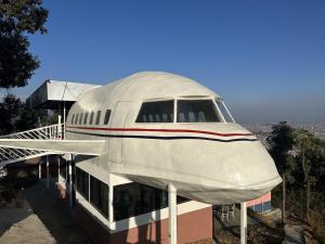 加德满都Kankali Viewpoint Resort Pvt Ltd的坐在大楼顶部的白色飞机