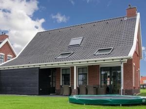 科莱恩斯普拉特Vacation home with sauna in Zeeland的一个带 ⁇ 顶和蹦床的房子