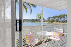 黄金海岸64 Isle of Palms的一个带桌椅的门廊,享有水景