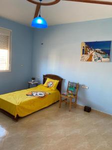 萨伊迪耶Spacious and Cozy Villa for Peace of Mind, Saidia的一间卧室配有黄色的床和椅子