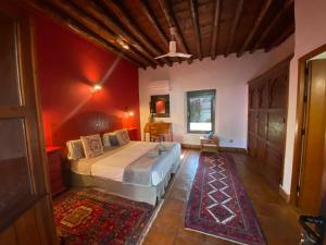 隆达La Guzmana de Ronda的一间卧室设有一张带红色墙壁的大床
