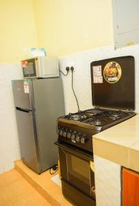 NyahururuThe escape, nyahururu.的厨房配有炉灶和冰箱。