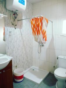 雅温得Residence Jardin Tropical的浴室设有卫生间和带雨伞的淋浴。