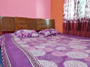 达卡Hotel Short Time Stay的一张紫色床,上面有两个枕头