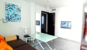 塞维利亚Triana, Lovely Flat+Pool的客厅配有玻璃桌和沙发